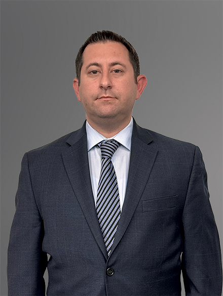 Attorney Richard Rieders in a Navy Suit with a White Shirt and Gray Patterned Tie